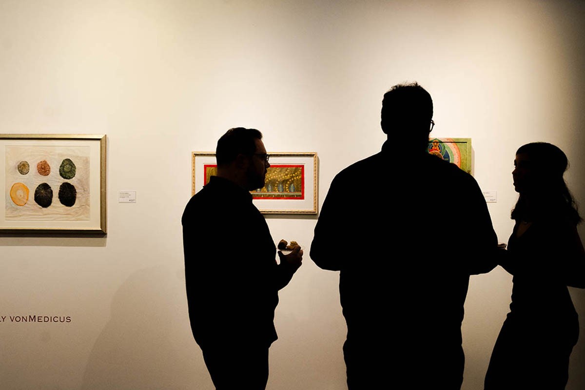 exhibitions-page-2.0 Three individual silhouettes standing in front of art pieces