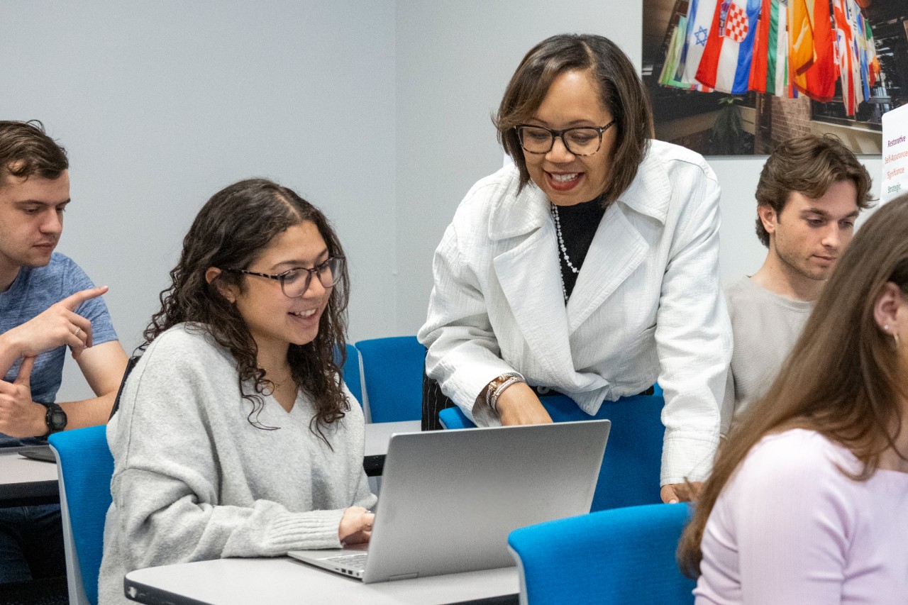 Career Center staff member and student looking at laptop together.