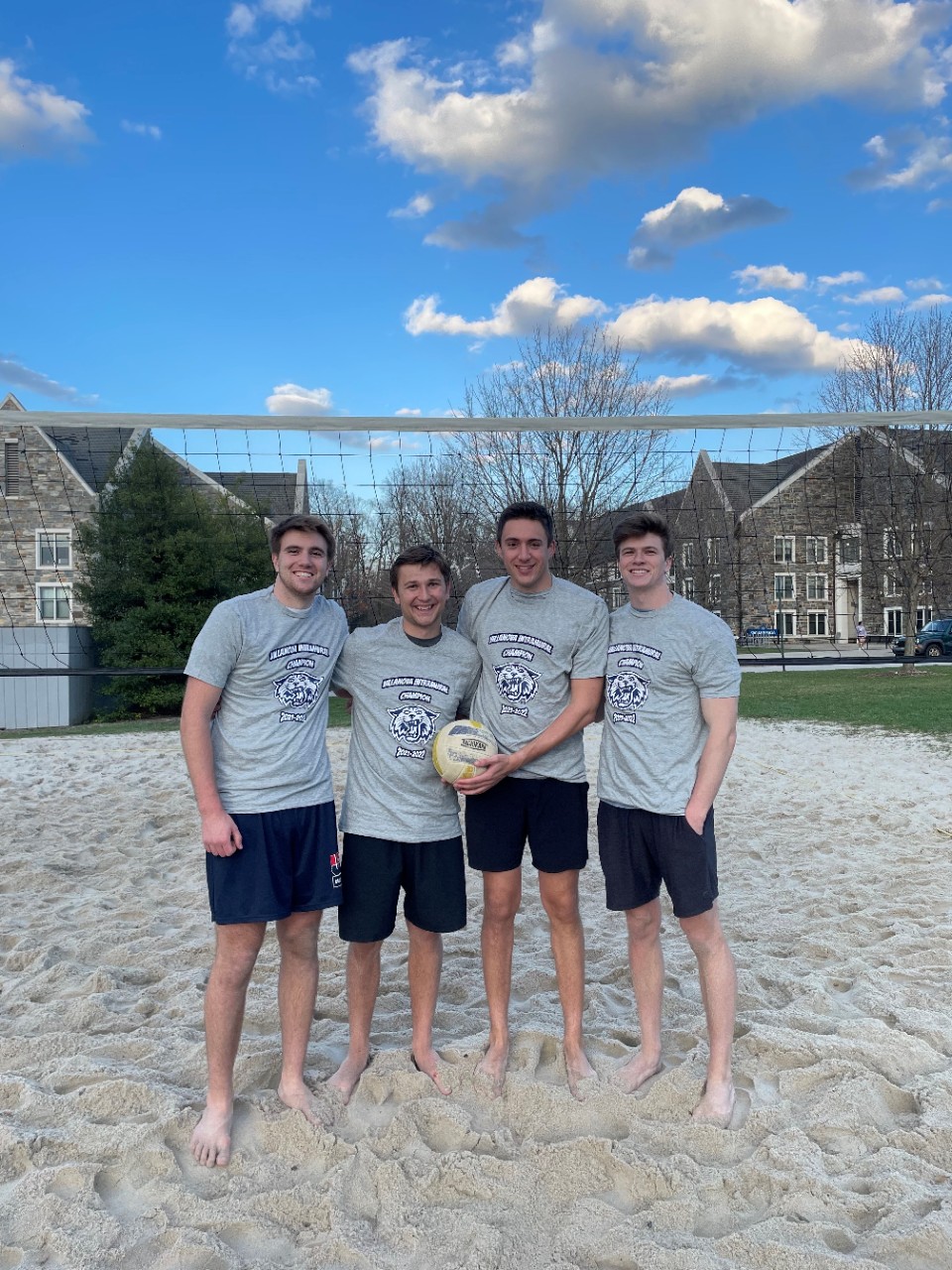 Male students posing for sand volleyball champion photo