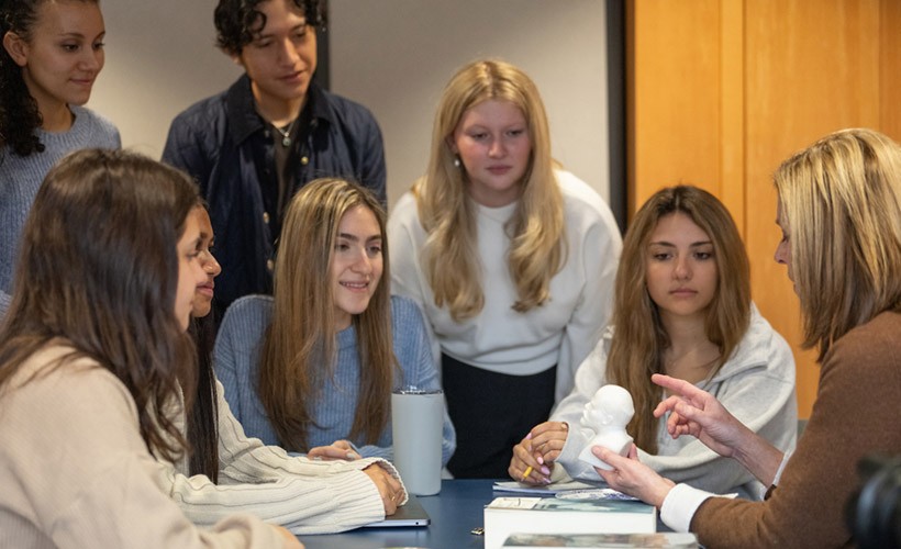 image of students and teacher seated around table