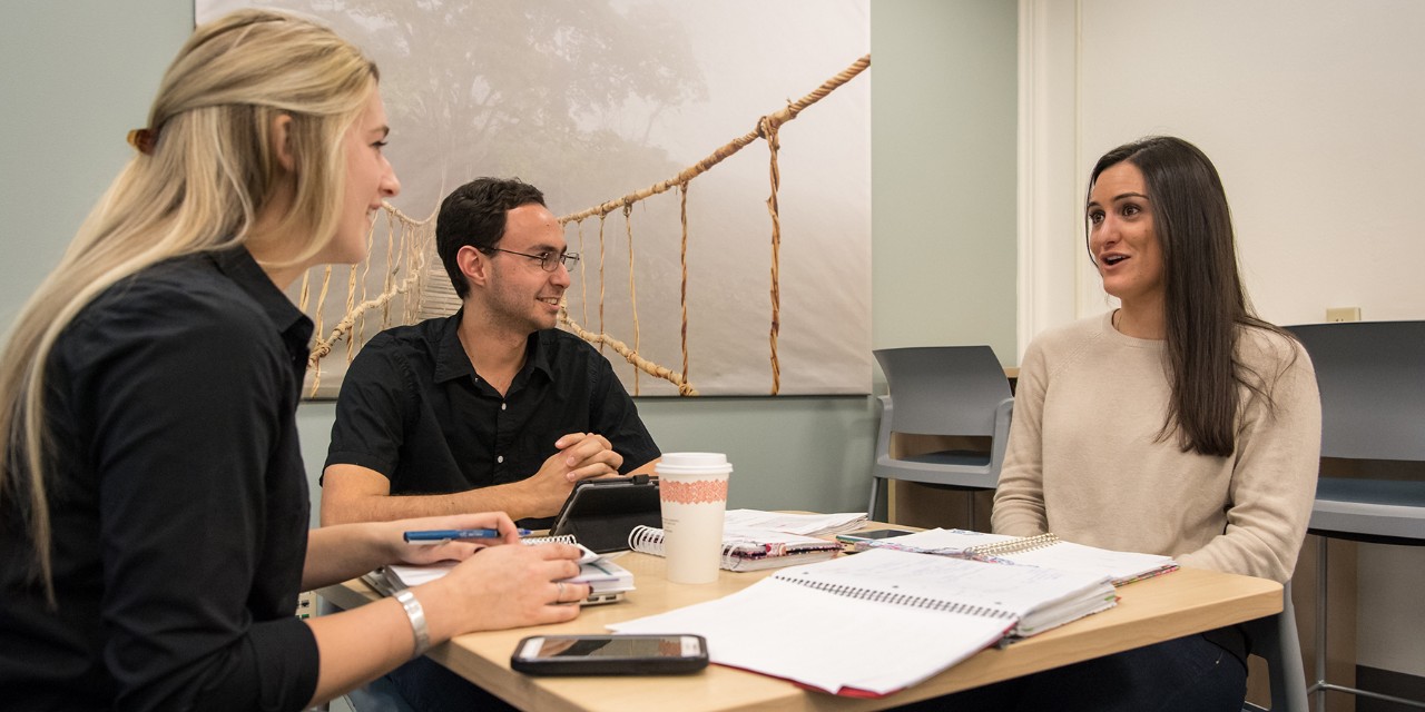 Graduate students in discussion around a table