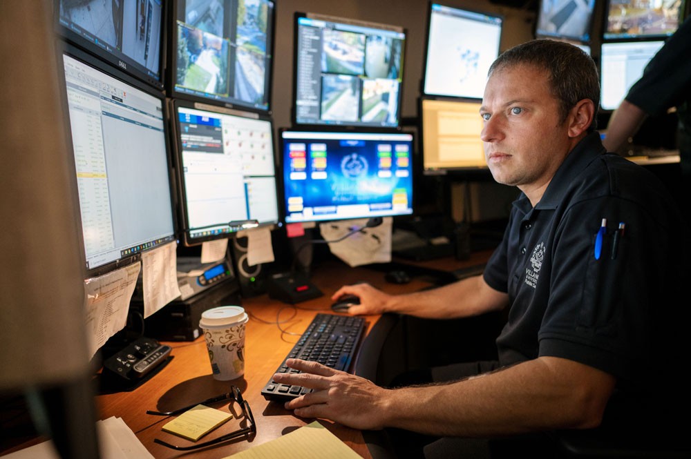 Campus security watch Public safety officer at desk with computer monitors