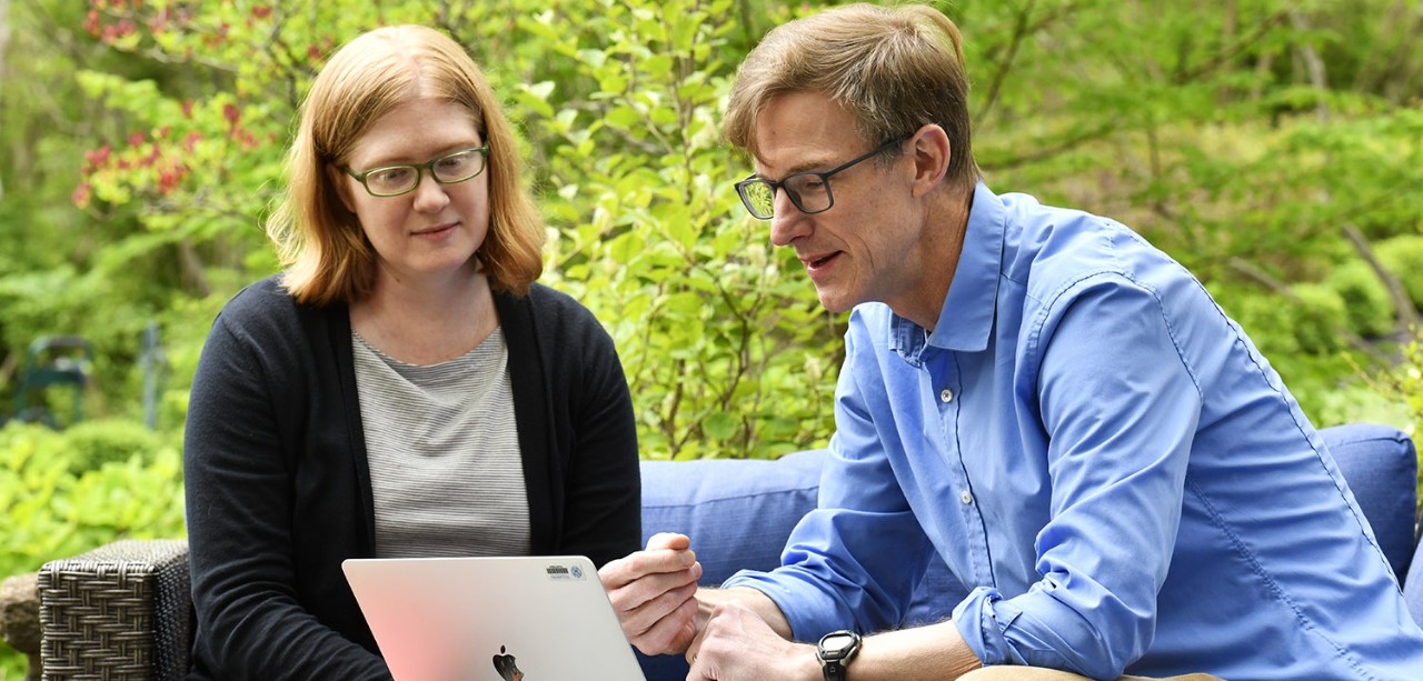 Faculty sitting outside working on a laptop