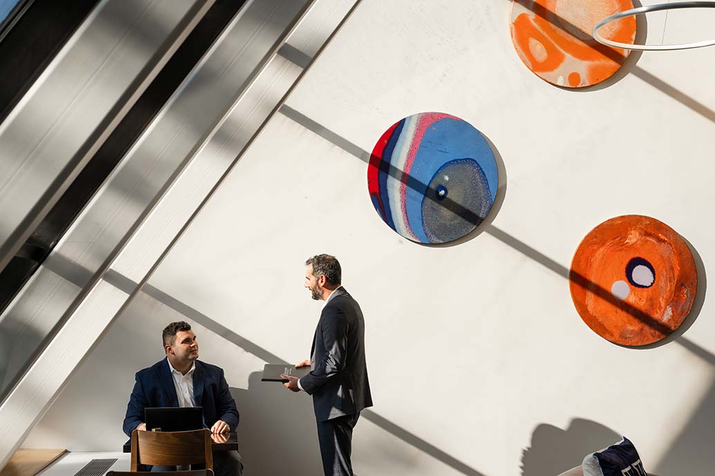 A male professor and male students meeting in café.