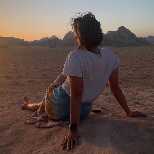 the back of a woman sitting on a beach