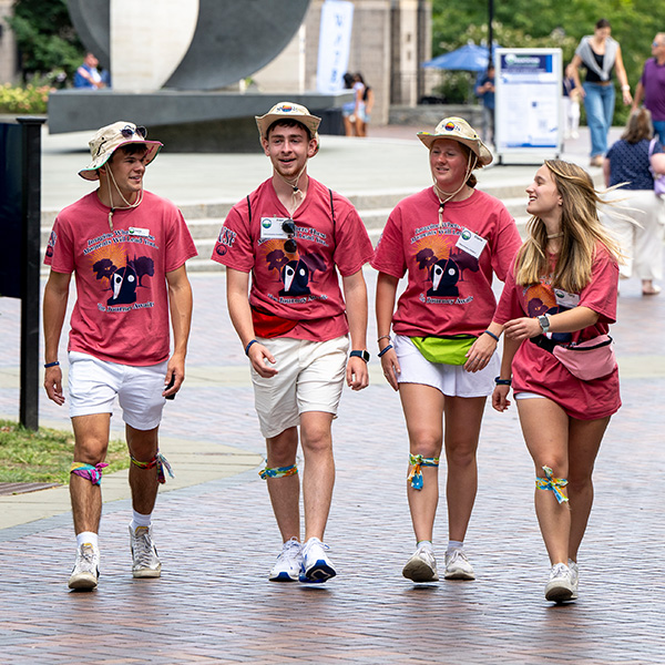 Four Orientation counselors walk across campus. 