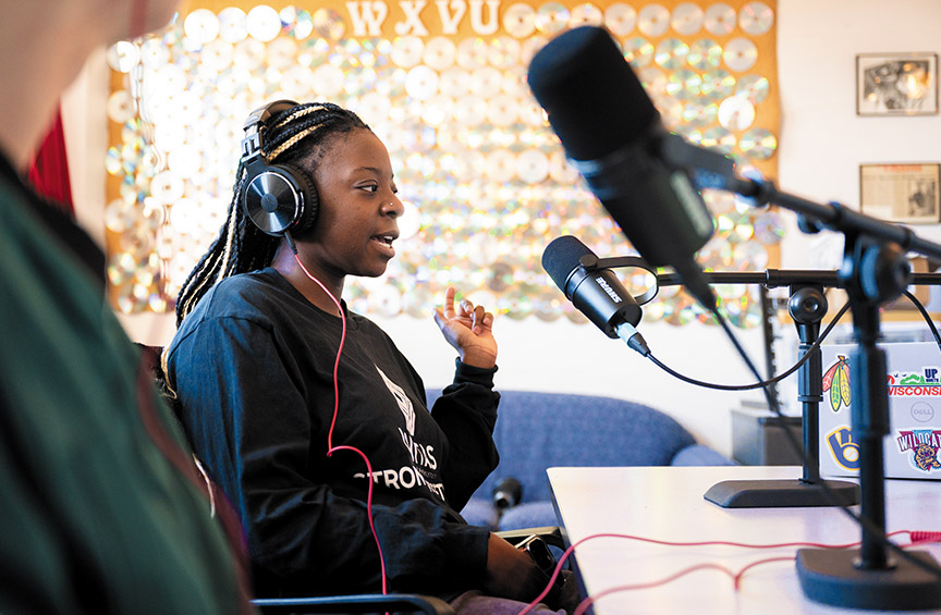 a guest of the Morning Roar radio show wears headphones and speaks in front of a microphone 